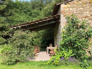 Saint-MoreilLe Moulin de la Farge B&B的一个带木桌和石墙的花园