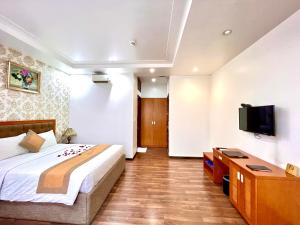 胡志明市New Space Hotel Airport的一间卧室配有一张床和一台平面电视