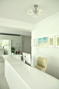 斯基亚索斯镇Anemoni Beach Hotel的白色的厨房配有白色的柜台和椅子