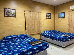 七岩Loongmun Beach的配有蓝色床单的客房内的两张床
