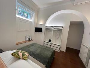 罗马Eccelso Suites的一间卧室设有一张床和一个拱形窗户