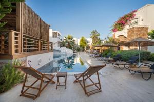 博德鲁姆Costa Sariyaz Hotel Bodrum的一个带椅子的庭院和一个游泳池