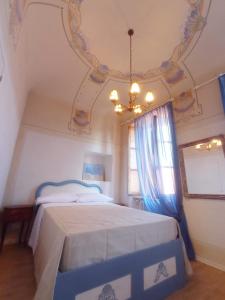 阿夸维瓦皮切纳Hotel Oviv dimora del borgo的一间卧室配有一张床和一个吊灯