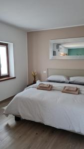 Dario Coos srl - Azienda vinicola的白色卧室配有一张大床和两条毛巾