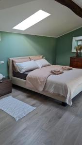 Dario Coos srl - Azienda vinicola的一间卧室,在绿色的墙上配有一张大床
