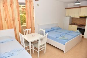 都拉斯Vila Namiku的一间带两张床和一张桌子的卧室以及一间厨房