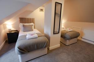 莱德林赫林木瀑布旅馆的一间小卧室,配有两张床和镜子