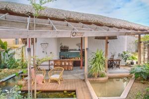 An Bàn (2)Pao Homes - An Bang Beach Stone Villa的房屋前方设有带池塘的庭院