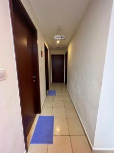 迪拜Robin Beach Hostel JBR的走廊上设有蓝色垫子,地板上设有门