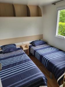 拉尔罗Camping Ixtila mobilhome的两张床位于带窗户的房间内