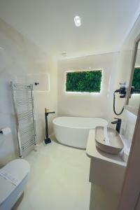 Tîrgu FrumosHotel Coroana的白色的浴室设有浴缸和卫生间。