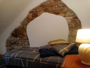 NosówAgroturystyka Camp4x4的石墙房间内的一张床位