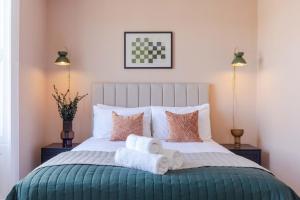 爱丁堡Dragon Suites Luxury Serviced Apartments at Walker Street的一间卧室配有带毛巾的床