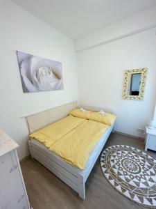鲍洛通拜雷尼Gyöngybagoly Apartman的小卧室配有一张黄色毯子床
