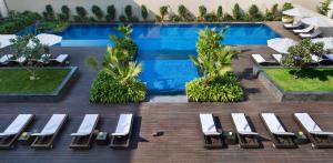新德里新德里空港JW万豪酒店的享有带白色躺椅的游泳池的顶部景致