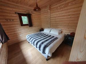 Le Vigen杜瑞诺山林小屋的小木屋内一间卧室,配有一张床