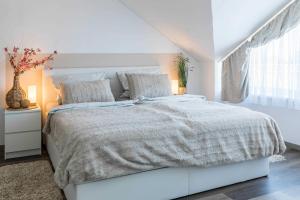 沃伦伯格Haus Seeblick Wohnung 16的白色的卧室设有一张大床和一个窗户