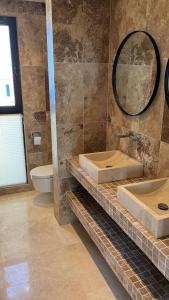 布德瓦Family Vacation Villa Rezevici的一间带两个盥洗盆和卫生间的浴室
