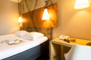鲁汶宜必思勒芬中心酒店的酒店客房配有一张床、一张书桌和一部电话