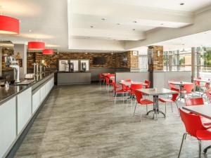赫尔赫尔市中心宜必思酒店的一间餐厅,房间内设有红色的椅子和桌子