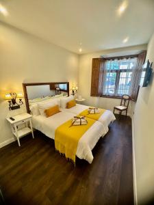 坎加斯德尔纳尔塞亚CLAREN´S BOUTIQUE ROOMS的一间卧室配有一张带黄色毯子的大床