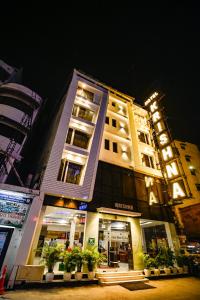 新德里Hotel Krishna - By RCG Hotels的一座在晚上有植物的建筑