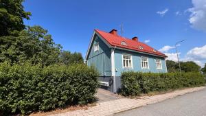 图尔库Tunnelmallinen puutalohuoneisto.的街上有红色屋顶的蓝色房子