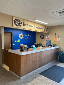 格伦代夫SureStay by Best Western Glendive Yellowstone River的大堂欢迎客人到墙上的格兰维尔标志