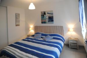 莱萨布勒-多洛讷海洋公寓酒店的卧室配有蓝色和白色条纹床