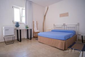 滨海波利尼亚诺马塞里亚吉安格兰德客房旅馆的卧室配有1张床、1张桌子和1把椅子