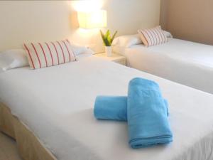 阿德耶洛杉矶奥利沃斯海滩度假公寓的一间卧室配有两张床和蓝色毛巾。