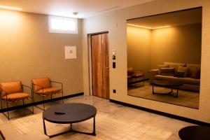 马塞拉韦尔Spa酒店的一间备有橙色椅子和镜子的等候室