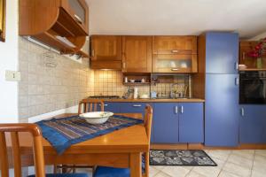 萨萨里Casetta Brandinu的厨房配有蓝色橱柜和木桌
