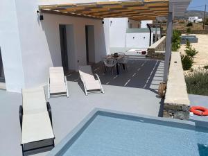 帕罗斯岛Bluebell Resort Villa SUNSET的庭院设有游泳池、椅子和桌子。