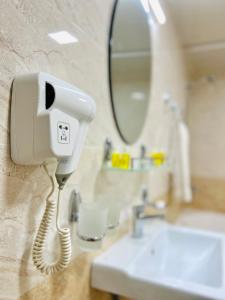 布哈拉考米尔精品酒店的浴室水槽旁墙上的电话
