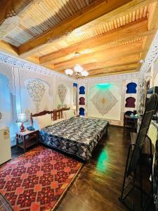 布哈拉考米尔精品酒店的一间卧室,卧室内配有一张床和地毯