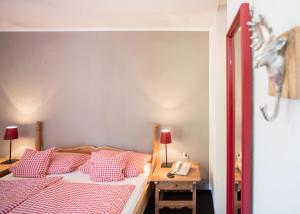 温特贝格Boutique-Hotel Weigels Bergfreiheit的一间卧室配有红色和白色枕头的床