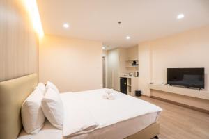 Ban Khlong ThewaOriole Residence - Suvarnabhumi的卧室配有白色的床和平面电视。