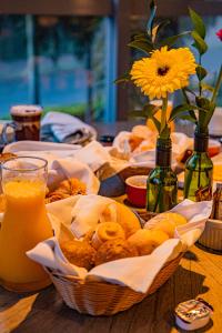 阿雷格里港Hotel Laghetto Stilo Higienópolis的一张桌子,上面放着一篮子的食物和一杯橙汁