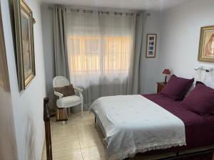 卡内·德·玛尔Big & cozy beach canet de Mar的卧室配有床、椅子和窗户。
