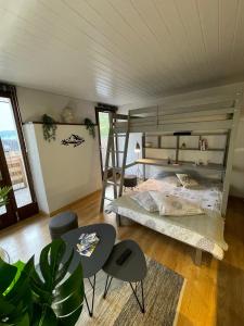 梅塔比耶Au Doubs Village的一间卧室配有一张双层床和一张桌子及椅子。