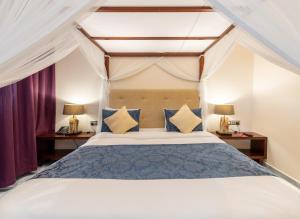 LimuruMuthu Sovereign Suites & Spa, Limuru Road, Nairobi的一间卧室配有蓝色和黄色枕头的床