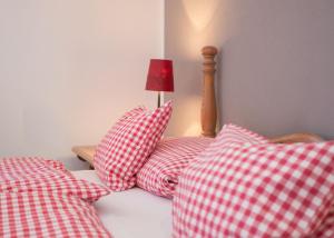 温特贝格Boutique-Hotel Weigels Bergfreiheit的一张带红白色枕头和灯的床