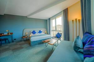 卡萨布兰卡Kyriad Residence Casablanca的蓝色的客房配有床和沙发