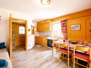 博萨迪法萨Apartment Brunel-2 by Interhome的厨房配有木制橱柜和桌椅