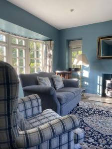 莱德林赫The Old Coach House的蓝色的客厅配有沙发和椅子