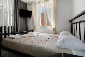 沃丽曼村Villa Drosia的一间卧室,床上有红色玫瑰