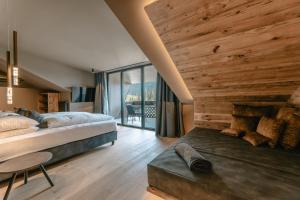 卡雷扎湖Hotel Alpenrose的一间卧室配有一张床、一张桌子和一个大窗户