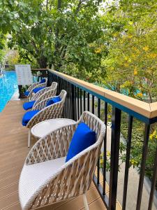 华欣Pool Access La Habana HuaHin Managed By Asiabb的阳台上的一排带蓝色枕头的椅子