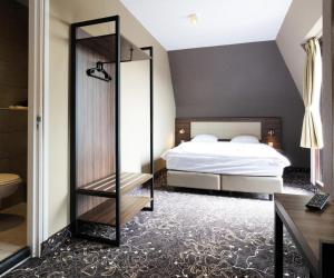 巴德胡弗多普Amsterdam Lake Hotel的一间卧室配有一张床和镜子